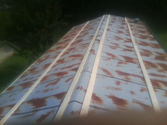 Rusted metal roof panels with new wood purlins before replacement — Storm Damage Roof Repair in Newland by Roofing Brothers