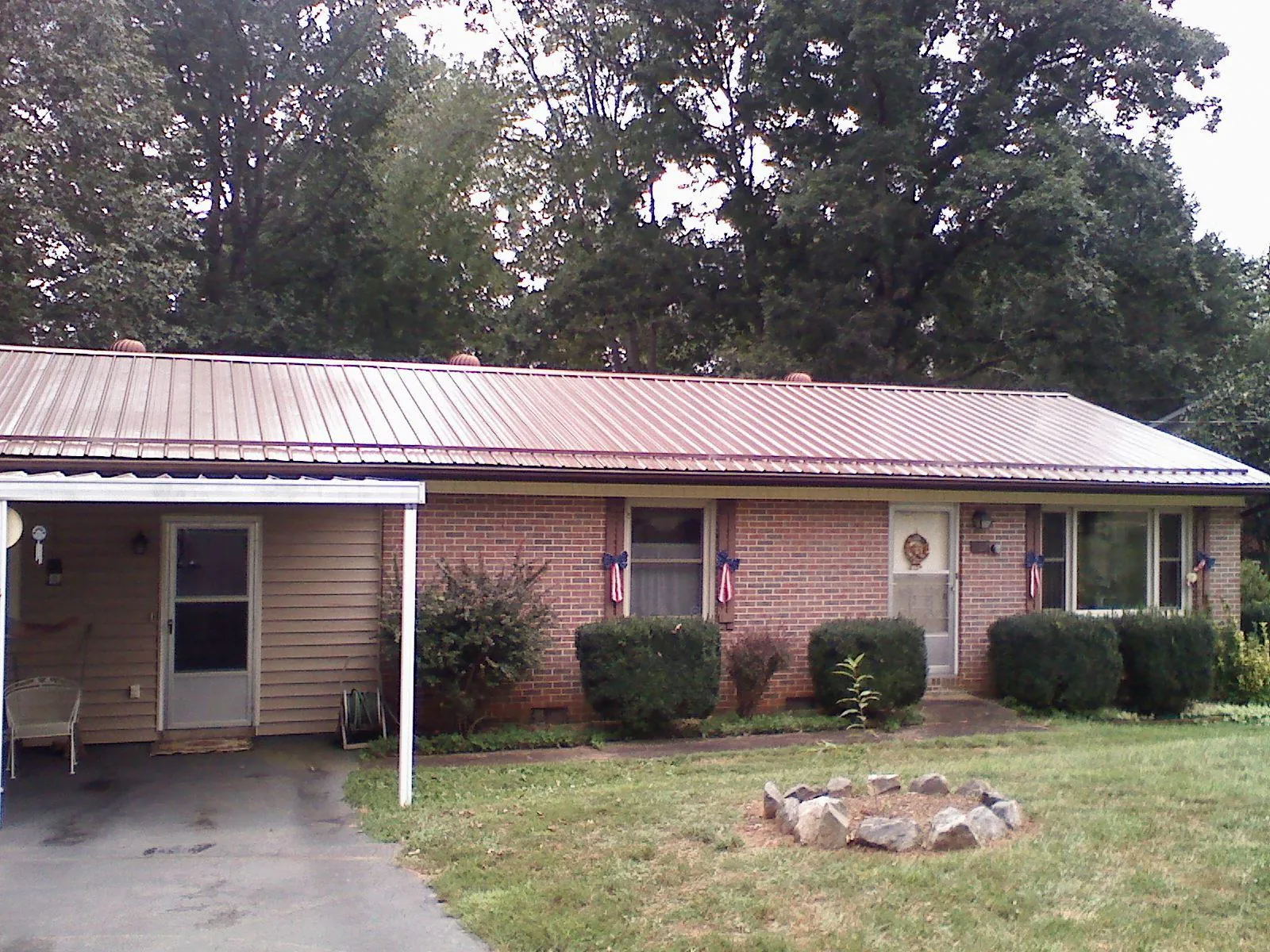 Bronze metal roof and carport on a brick ranch home — Roof Repair work by our crew in Newland